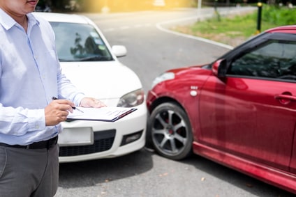 stockfresh_9488279_insurance-agent-writing-on-clipboard-while-examining-car-after-a_sizeXS-min